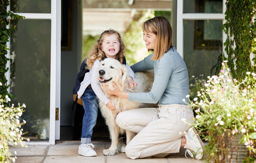 Shot of a mother and daughter bonding with their dog in the backyard at home
